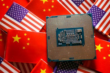 A central processing unit (CPU) semiconductor chip is displayed among flags of China and U.S., in this illustration picture taken February 17, 2023.