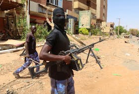 A member of Sudanese armed forces looks on as he holds his weapon in the street in Omdurman, Sudan, March 9, 2024.