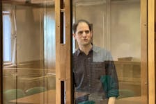 Wall Street Journal reporter Evan Gershkovich, who is in custody on espionage charges, stands behind a glass wall of an enclosure for defendants as he attends a court hearing to consider extending his detention in Moscow, Russia, March 26, 2024. Moscow City Court's Press Office/Handout via