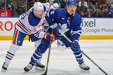 Zach Hyman of the Edmonton Oilers skates against Simon Benoit of the Toronto Maple Leafs during a game.