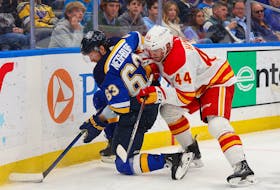 Jake Neighbours #63 of the St. Louis Blues battles Joel Hanley #44 of the Calgary Flames for control of the puck in the third period at Enterprise Center on March 28, 2024 in St Louis, Missouri. (Photo by Dilip Vishwanat/Getty Images)