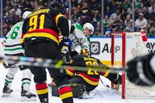 Dallas Stars' Roope Hintz, back centre, scores against Vancouver Canucks goalie Casey DeSmith during the first period of an NHL hockey game in Vancouver, on Thursday, March 28, 2024.