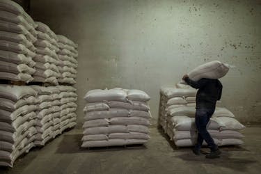 A worker carries a bag of animal feed at the Union of Agricultural Cooperatives on the island of Naxos, Greece, May 16, 2022.