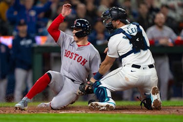 Mar 28, 2024; Seattle, Washington, USA; Boston Red Sox right fielder Tyler O'Neill (17) scores a run after a throw gets past Seattle Mariners catcher Cal Raleigh (29) during the fourth inning at T-Mobile Park. Mandatory Credit: Stephen Brashear-USA TODAY Sports