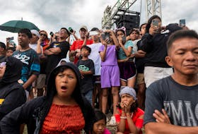 People watch the reenactment of the crucifixion of Jesus Christ on Good Friday, in San Fernando, Pampanga, Philippines, March 29, 2024.