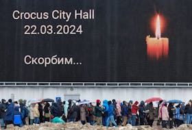 People line up to lay flowers at a makeshift memorial to the victims of a shooting attack set up outside the Crocus City Hall concert venue in the Moscow Region, Russia, March 24, 2024.
