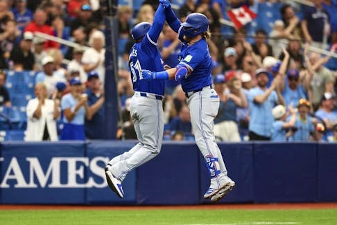 Justin Turner #2 of the Toronto Blue Jays celebrates with third base coach Carlos Febles #51 after hitting a home run during the fifth inning against the Tampa Bay Rays at Tropicana Field on March 31, 2024 in St Petersburg, Florida.