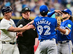Blue Jays pitcher Genesis Cabrera shoves Jose Caballero of the Rays as third base coach Brady Williams (left), umpire Corey Blaser (second left), and Bo Bichette (right) attempt to intervene in the seventh inning at Tropicana Field in St. Petersburg, Fla., Saturday, March 30, 2024.