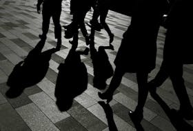 Workers cast shadows as they stroll among the office towers Sydney's Barangaroo business district in Australia's largest city, May 8, 2017. 