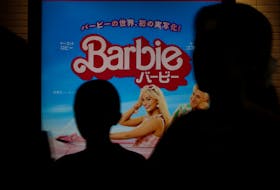 People walk past a promotional poster of film "Barbie" in Tokyo, Japan, August 3, 2023.