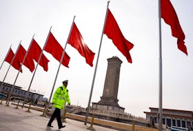 A police officer walks past red flags, on the day of the opening session of the Chinese People's Political Consultative Conference (CPPCC), at Tiananmen Square, in Beijing, China March 4, 2024.
