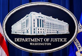 A U.S. Justice Department logo or seal showing Justice Department headquarters, known as "Main Justice," is seen behind the podium in the Department's headquarters briefing room before a news conference with the Attorney General in Washington, January 24, 2023. 
