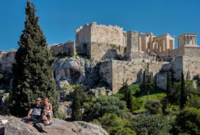 A couple takes selfies during a warm day at the Areopagus hill near the Acropolis in Athens, Greece, March 4, 2024.