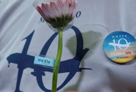 A family member of the missing Malaysia Airlines flight MH370 holds a flower during a remembrance event marking the 10th anniversary of its disappearance, in Subang Jaya, Malaysia March 3, 2024.