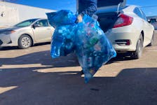 An employee gets bags of bottles and cans out of customer's car to recycle at A&S Bottle Exchange, Charlottetown. Pratik Bhattarai • The Guardian