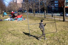 A worker carries a fence to fence off Victoria Park, one of the five sites de-designated as an encampment location, in downtown Halifax on Monday, March 4, 2024. The move is HRM's latest attempt to drive people out after the eviction date (Feb. 26) has passed.