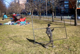 A worker carries a fence to fence off Victoria Park, one of the five sites de-designated as an encampment location, in downtown Halifax on Monday, March 4, 2024. The move is HRM's latest attempt to drive people out after the eviction date (Feb. 26) has passed.