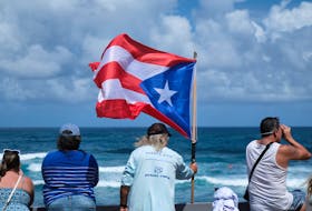 A man holds a Puerto Rican flag during day 5 of the ISA World Surfing Games in Arecibo, Puerto Rico, February 28, 2024.