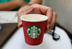 A woman displays a red Starbucks cup at a Starbucks cafe in Beirut, Lebanon November 20, 2016.