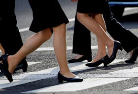 Women in high heels walk at a business district in Tokyo, Japan, June 4, 2019. 