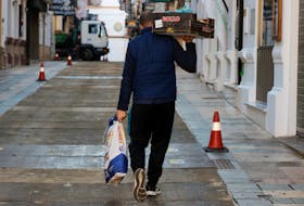 A delivery worker carries food for a restaurant in Ronda, southern Spain, January 3, 2023.
