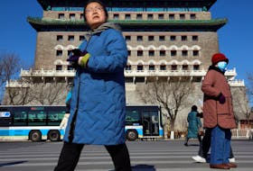Pedestrians walk on a crossing near the Qianmen Gate in Beijing, China January 26, 2024.