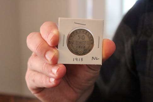 Bradley Reid of St. John's has been collecting coins for nearly a decade. He said he has 12 Newfoundland coins in his collection. In his hand is a 50-cent sliver coin from 1918. - Cameron Kilfoy/The Telegram