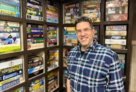 Montague resident Rodney Smith, who is the founder of the YouTube channel “Watch It Played” dedicated to board games, stands before his shelves full of games featured in the tutorial videos on his channel. Thinh Nguyen • The Guardian