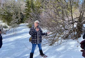 Biologist and naturalist Kate MacQuarrie shows attendees of a two-hour nature walk various signs of animal presence. These including snowshoe hare tracks and teeth marks around an apple tree. Caitlin Coombes • Local Journalism Initiative reporter
