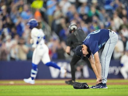 George Kirby of the Seattle Mariners adjusts his shoes as Bo Bichette of the Toronto Blue Jays rounds third after hitting a home run in the third inning at the Rogers Centre on Tuesday, April 9, 2024, in Toronto.