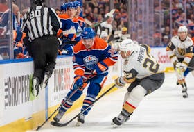 Sam Carrick #39 of the Edmonton Oilers and Alec Martinez #23 of the Vegas Golden Knights battle for the puck along the boards at Rogers Place on April 10, 2024, in Edmonton.
