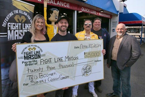 WINDSOR, ONT: APRIL 10, 2026.  Chantelle Bacon and Iain Macri, left, with the Fight Like Mason Foundation, pose on Wednesday, April 10, 2024 with a ceremonial check with Rick Rock, lead singer of the Simply Queen band, Peter Solly, owner of the MacDonald's Automotive Supercentre and Mario Ricci, organizer of a recent fundraising concert. A total of $23,000 was donated to the foundation from the auction of Solly's metal fabric statue of Freddie Mercury that was sold during the concert event.