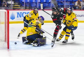 Canada's Renata Fast (14) scores on Swedish goalie Emma Soderberg during quarter-final action at the IIHF World Women's Championship on Thursday night in Utica, N.Y. Canada won 5-1. - Hockey Canada