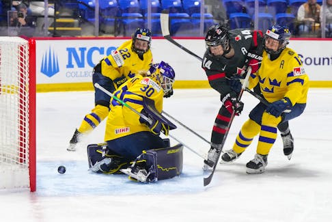 Canada's Renata Fast (14) scores on Swedish goalie Emma Soderberg during quarter-final action at the IIHF World Women's Championship on Thursday night in Utica, N.Y. Canada won 5-1. - Hockey Canada