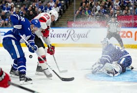 Maple Leafs' Mark Giordano (55) and New Jersey Devils' Kurtis MacDermid vie for control of the puck as Leafs goaltender Ilya Samsonov defends during the third period in Toronto, Thursday, April 11, 2024.