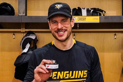 Pittsburgh Penguins centre Sidney Crosby holds the puck from his 1,000th career assist. - Pittsburgh Penguins
