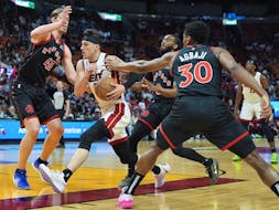 Miami Heat guard Tyler Herro drives through the defence of Toronto Raptors forward Kelly Olynyk (41), guard Javon Freeman-Liberty (0), and guard Ochai Agbaji (30) during the first half of an NBA basketball game, Sunday, April 14, 2024, in Miami. 