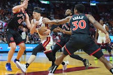 Miami Heat guard Tyler Herro drives through the defence of Toronto Raptors forward Kelly Olynyk (41), guard Javon Freeman-Liberty (0), and guard Ochai Agbaji (30) during the first half of an NBA basketball game, Sunday, April 14, 2024, in Miami. 