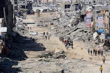 Palestinians inspect destroyed residential buildings, after the Israeli military withdrew most of its ground troops from the southern Gaza Strip, amid the ongoing conflict between Israel and Hamas, in Khan Younis, in the southern Gaza Strip April 7, 2024.