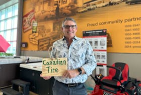 Cameron Beach, owner-operator of Charlottetown’s Canadian Tire, holds up the small wooden sign he found outside the store on the morning of April 12. He later connected with the sign's maker, leading to a $5,000 donation to the provincial Cancer Treatment Center on behalf of this person. Thinh Nguyen • The Guardian