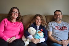 Lucie Gallant, centre, this year’s Easter Seals ambassador, is joined by her parents, Melissa, left, and Christopher at their home in Sherbrooke, P.E.I. The 10-year-old says it makes her uncomfortable when people do not consider her disabled despite the fact she is autistic and has ADHD. Dave Stewart • The Guardian