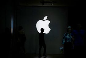 People walk near an Apple logo outside its store in Shanghai, China September 8, 2023.
