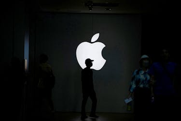 People walk near an Apple logo outside its store in Shanghai, China September 8, 2023.