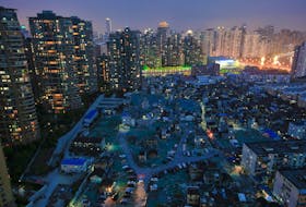 A night view of the old houses surrounded by new apartment buildings at Guangfuli neighbourhood in Shanghai, China, April 10, 2016.