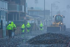 Work crews clean up a beach front road after ocean waves caused by a winter storm pushed up beach rocks in Oceanside, California, U.S., February 20, 2024. 