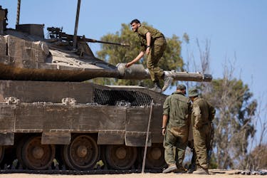 Israeli soldiers stand next to a tank, near the Israel-Gaza border, amid the ongoing conflict between Israel and the Palestinian Islamist group Hamas, in Israel, April 15, 2024.