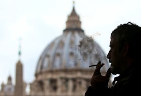 A man smokes a cigarette in front of St. Peter Square, in Rome, Italy November 9, 2017.