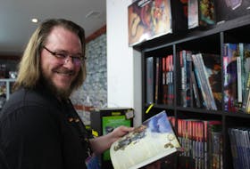 Brandon Massey holds a guidebook for Dungeons and Dragons. Guide books have hundreds of differing rules that change depending on the edition, time of publishing and group that publishes them. Justine Talla • Special to The Guardian