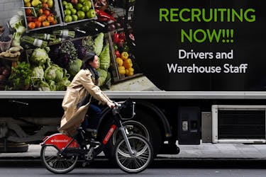 File photo: A cyclist rides past a sign on the side of a delivery lorry advertising for jobs, in London, Britain, October 13, 2021.