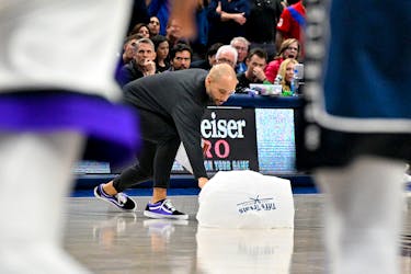 Nov 19, 2023; Dallas, Texas, USA; Sacramento Kings associate head coach Jordi Fernandez picks up a parachute giveaway item that fell onto the court during play during the second half of the game between the Dallas Mavericks and the Sacramento Kings at the American Airlines Center. Mandatory Credit: Jerome Miron-USA TODAY Sports